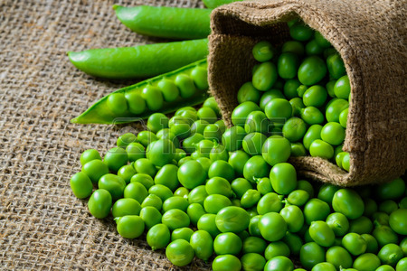 41256287-hearthy-fresh-green-peas-and-pods-on-rustic-fabric-background